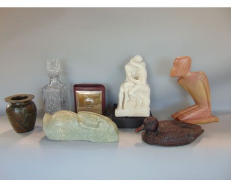 A collection of miscellaneous items to include a CD case with silver panel to the front, an Inuit type carving, a decoy duck,