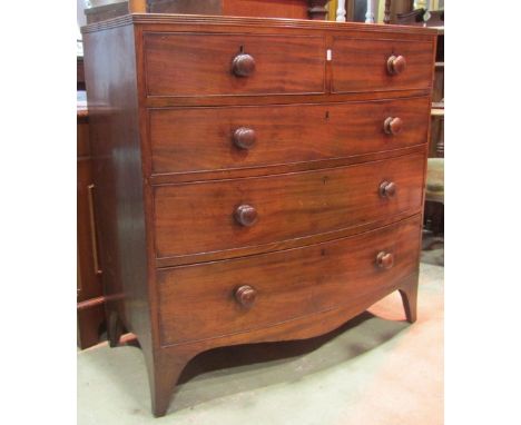 An early 19th century mahogany bow fronted caddy top bedroom chest of two short and three long graduated drawers with shaped 