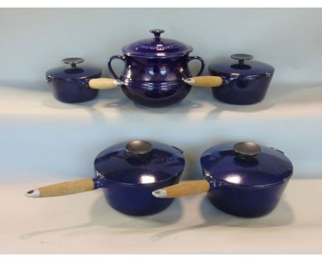 Le Creuset ceramic twin handled casserole pot, together with four graduated navy blue enamel saucepans in the Le Creuset mann