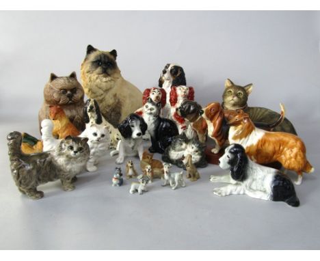 A collection of ceramic cats and dogs including a pair of 19th century Staffordshire spaniels with red painted patches, a Bes