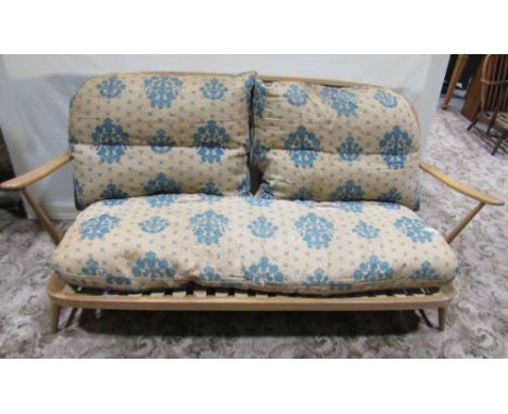 An Ercol light beechwood three piece lounge suite comprising a low three seat sofa with hoop and stick back and a pair of mat