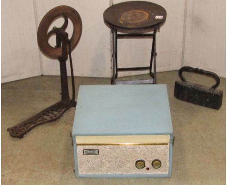 A small vintage folding industrial work stool with circular seat and X framed supports, together with a cast iron foot pedal 