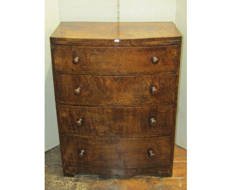 A small good quality oak bow fronted chest of four long graduated drawers, with caddy top raised on a shaped frieze, 72cm wid