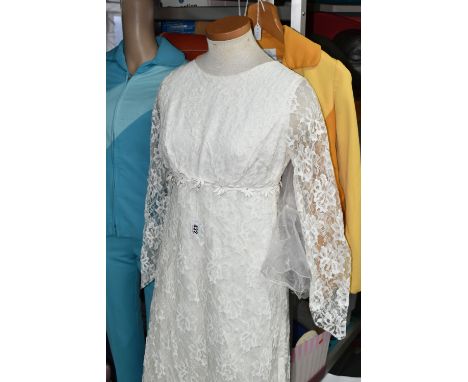 A SHOP MANNEKIN AND THREE 1970S LADIES' OUTFITS, comprising a cream long sleeved lace wedding dress with a chapel length lace