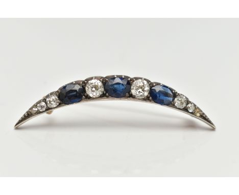 A LATE VICTORIAN DIAMOND AND SAPPHIRE CRESCENT BROOCH, set with three oval cut blue sapphires, interspaced with six old cut d