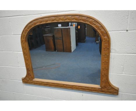 A PINE OVERMANTEL MIRROR, with a domed top and foliate decoration, width 130cm x height 90cm (condition report: some paint ma