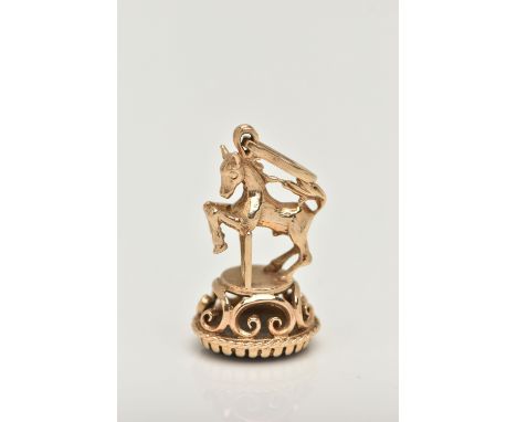 A 9CT GOLD FOB SEAL, in the form of horse jumping a gate, hallmarked 9ct London, on a round base set with an onyx inlay, fitt