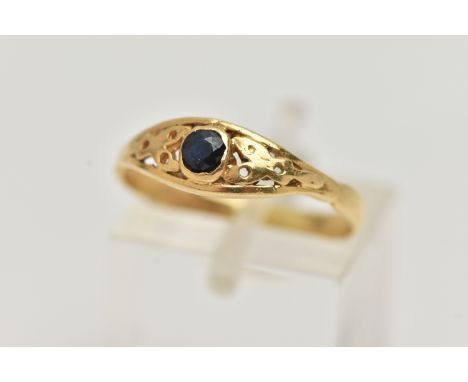 A YELLOW METAL SAPPHIRE RING, set with a single circular cut dark blue sapphire, open work surround, to the polished band, st