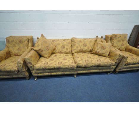 A HIGH QUALITY GOLD AND FLORAL UPHOLSTERED THREE PIECE LOUNGE SUITE, comprising large knole two seater sofa, with drop ends, 