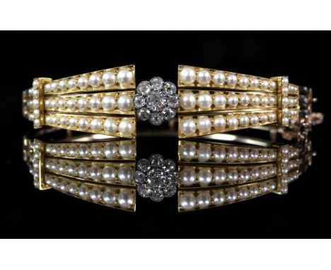 1930's bangle, centrally set with nine old cut diamonds, estimated total diamond weight 0.50 carats, with rows of pearls set 