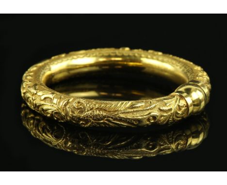 Chinese gold bangle with decoration of a dragon and exotic bird in relief, ball screw fitting, stamped marks, testing as 20 c