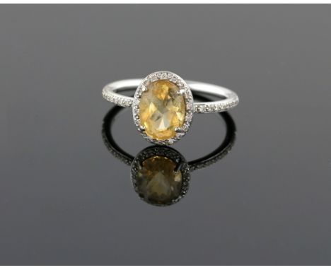 Citrine and diamond dress ring, oval cut citrine, with round brilliant cut diamond border and shoulders, mount stamped 18 ct,