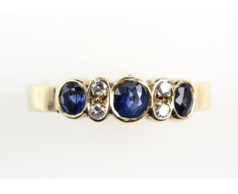 Contemporary sapphire and diamond ring with three sapphires in rub over setting, and two brilliant cut diamonds, in 9 ct gold