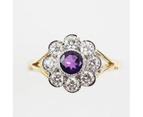 Diamond set flower head ring with central amethyst, estimated total diamond weight 0.65 carats, mounted in 18 ct gold, ring s