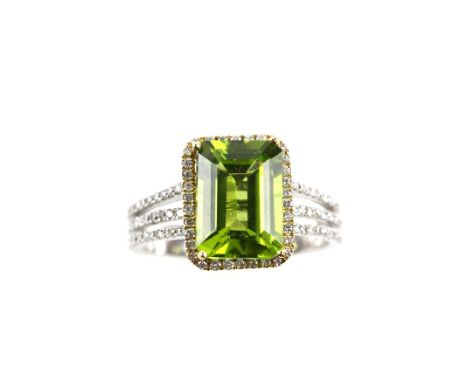 Modern diamond and peridot set dress ring, the central peridot  3.70 carats, diamond border and shoulders, 18 ct white gold, 