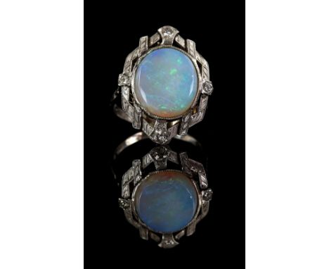 1950's opal and diamond ring, set with an oval opal, with four round brilliant cut diamonds set in each quarter, with a scrol