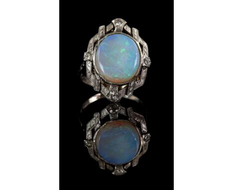 1950's opal and diamond ring, set with an oval opal, with four round brilliant cut diamonds set in each quarter, with a scrol