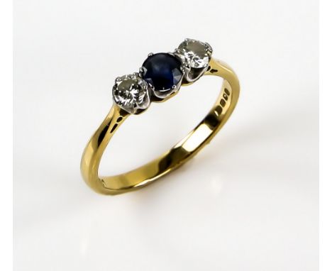 Three stone sapphire and diamond ring, with central round sapphire and two brilliant cut diamonds, total diamond weight 0.40 