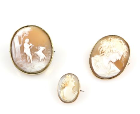 A cameo brooch depicting a piper and a dancing goat, and two portrait cameos, largest 4 cm  .      CONDITIONSmallest cameo mo
