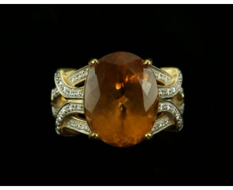 Dress ring set with large oval cut topaz and diamond set shoulders, stamped '750' for 18 ct gold, ring size N 1/2 .      COND