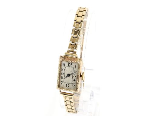 A 1920's ladies cocktail watch the rectangular gold case with foliate chased bezel, silvered dial with Arabic numeral hour ma