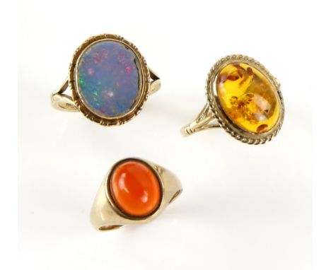 Three gem set rings, one set with opal doublet, ring size O, another one with oval cabochon cut amber, size P half and carnel