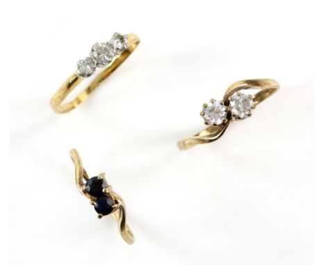 Three gem set rings, one set with three diamonds, size L another set with two round cut sapphires, size K and a double white 