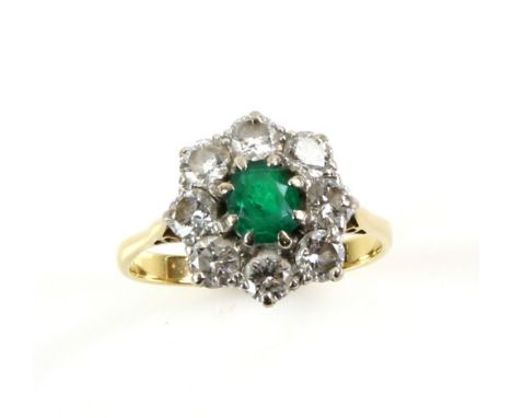 Emerald and diamond cluster ring, central oval cut emerald, set in a border of round brilliant cut diamonds, estimated total 