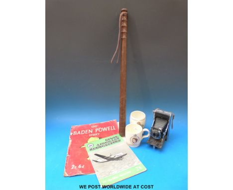 A wooden truncheon, folding camera, commemorative mugs and two magazines