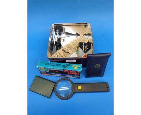 A tin of philatelic accessories including a Prinz UV test lamp