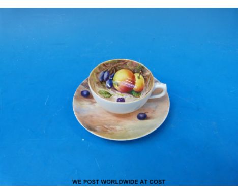 A cup and saucer hand-painted with fruit, the Royal Worcester saucer signed R Rushton, the cup signed W Hale