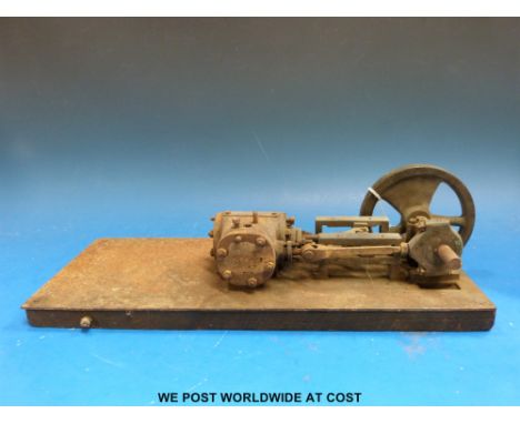 A horizontal stationary steam engine with fixed double action cylinder and 11.5cm diameter flywheel mounted on a base. Approx