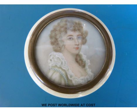 A Georgian round ivory snuff box, the lid having a portrait miniature of a lady wearing a white dress, diameter 5cm