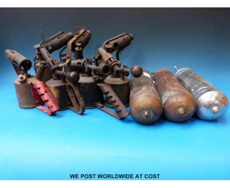 A collection of blow torches and three vintage fire extinguishers