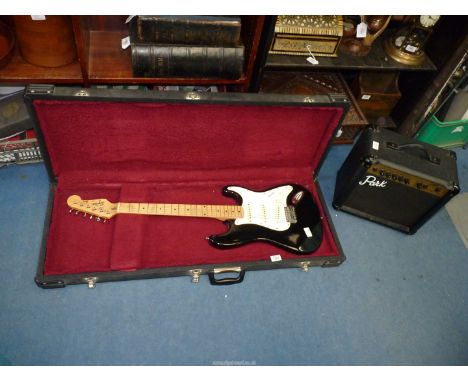 A Squire Stratocaster electric guitar by Fender in a lined hard case alongwith a Park model G10 amplifier.