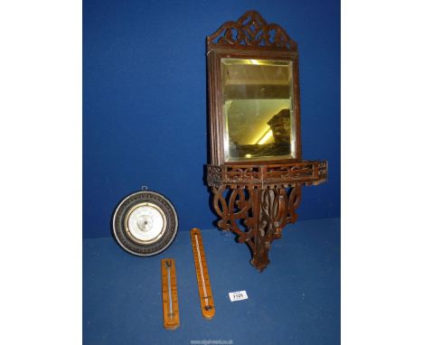 A Mahogany framed wall mirror with shelf and fretwork detail underneath, two thermometers and a small circular barometer.