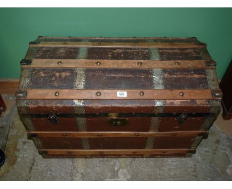 A domed top steamer trunk 33 1/4" wide x 22 1/2" high x 19" deep, some damage to top.