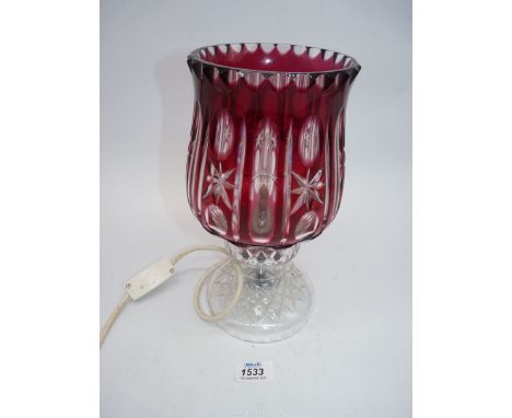 A cut glass table lamp with a clear and cranberry glass shade, 11" tall.