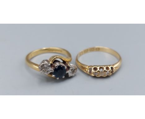 An 18ct gold three stone ring set with a central Sapphire flanked by Diamonds, 4.1gms, ring size G together with an 18ct gold
