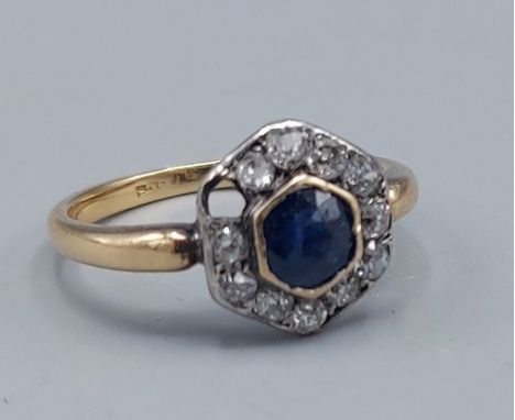 An 18ct gold Sapphire and Diamond cluster ring set with a central Sapphire surrounded by Diamonds, (one stone missing), 3.8gm