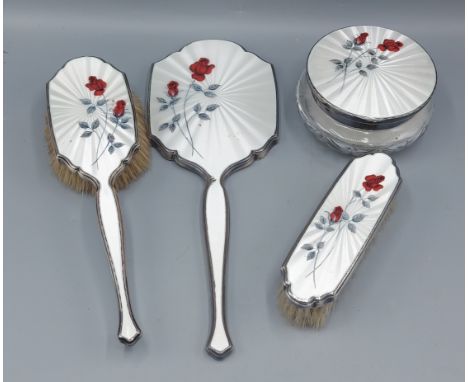 A London silver and enamel decorated four piece dressing table set comprising two brushes, a mirror and a compact
