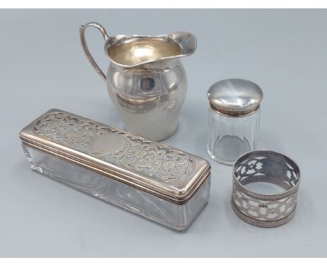 A Birmingham silver cream jug together with two silver topped dressing table jars and a silver napkin ring 
