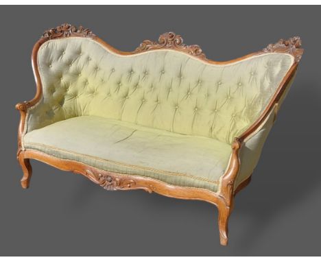 A Victorian sofa with double spoon back and button upholstered raised upon cabriole legs with scroll feet, 170cms long