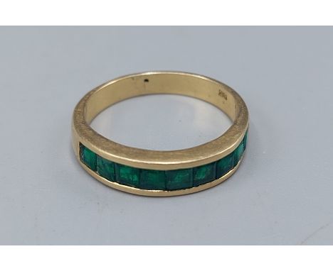 An 18ct gold Emerald band ring set with nine baguette cut Emeralds, 5.7gms, ring size T