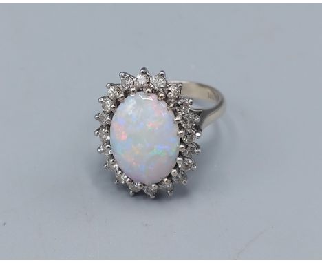 An 18ct white gold Opal and Diamond cluster ring, set with large central opal surrounded by Diamonds within a pierced setting