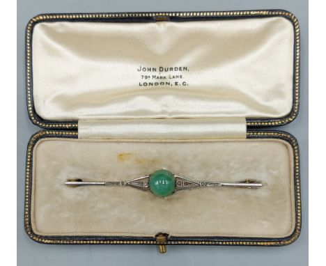 A yellow gold bar brooch set with central cabochon Jade and Diamonds, 7cms long, 4.8gms
