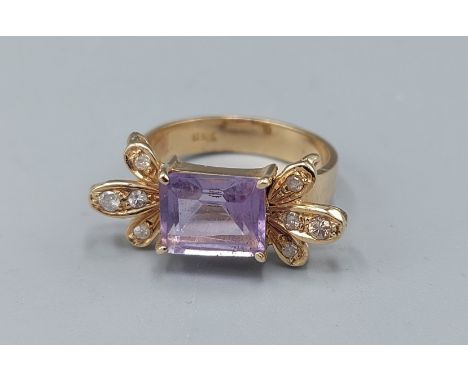 An 18ct gold ring set with central Amethyst and eight Diamonds, 5.6gms, ring size L