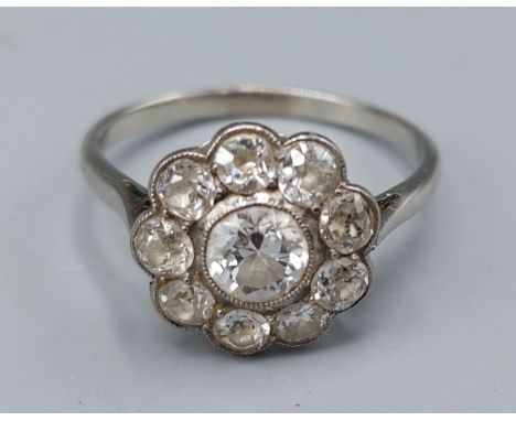 A white gold Diamond cluster ring set with a central Diamond, approx. 0.5ct, surrounded by Diamonds within a pierced setting,