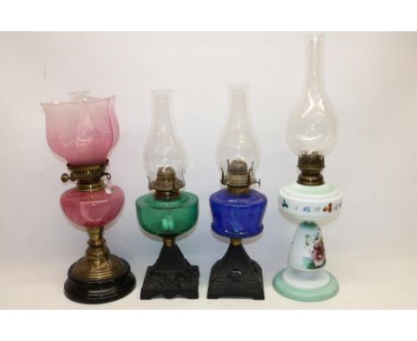 Three oil lamps with coloured glass reservoirs incl. one with shade, and a painted opaline glass oil lamp, max. H55.5cm incl.