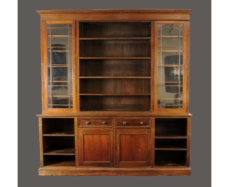 A large Victorian bookcase with two glazed doors flanking central shelf section over a base of doors and central drawers toge